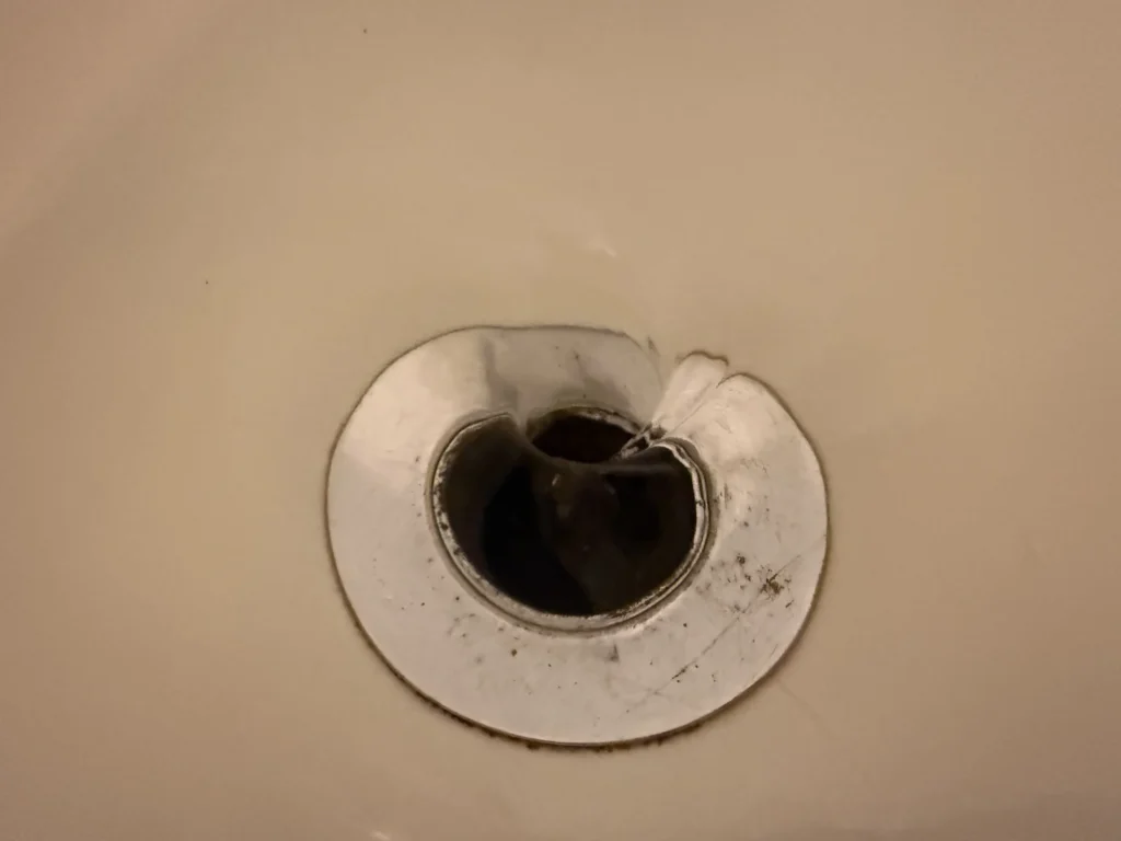 Water swirling down an open bathtub drain